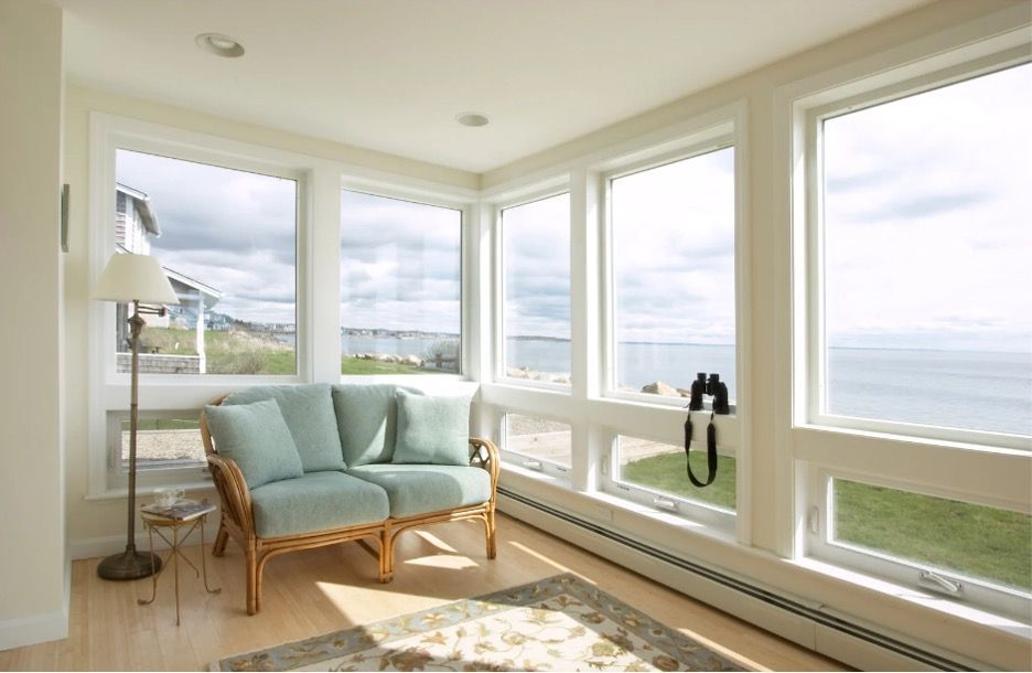 living room with two chairs and large awning windows
