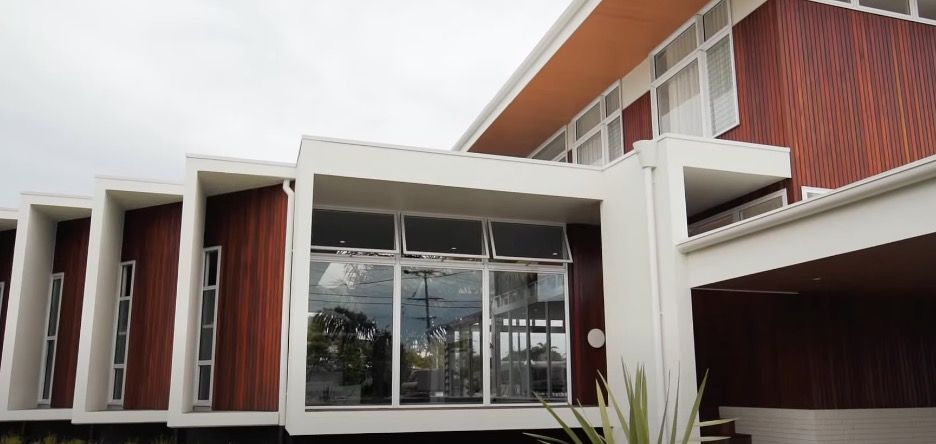 a wooden styled house with a awning windows in front