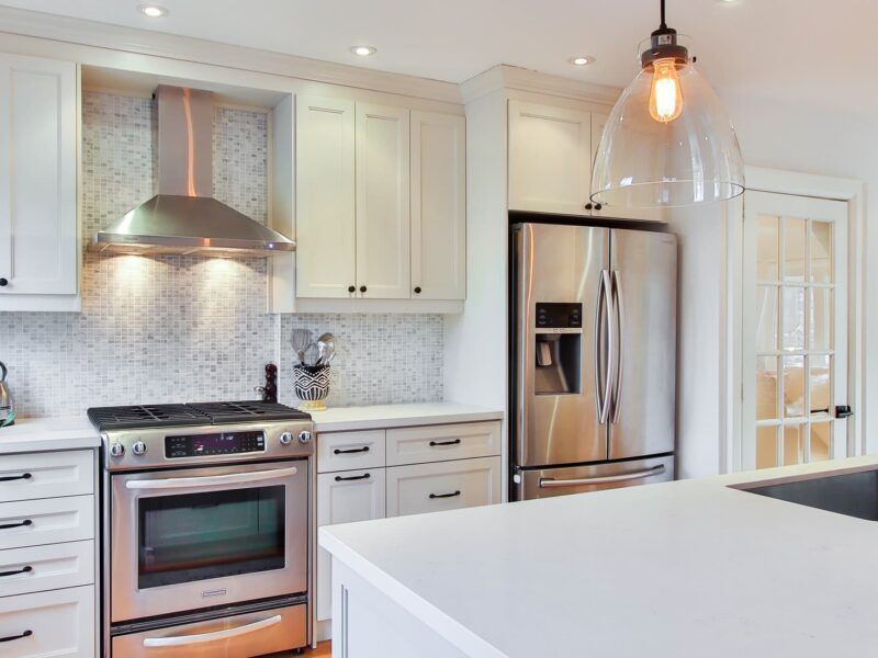 Bright modern kitchen with white cabinets, stainless steel appliances, and a large island