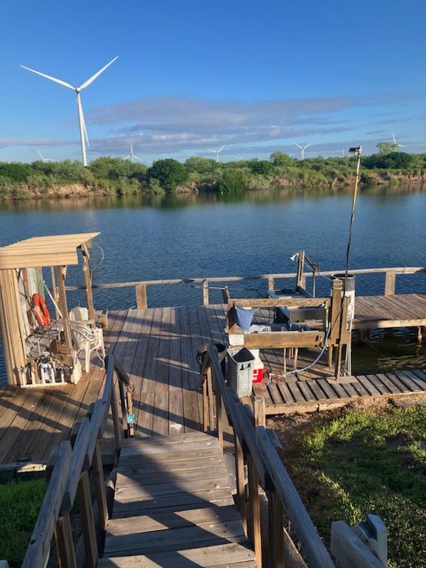 A wooden dock with a windmill in the background