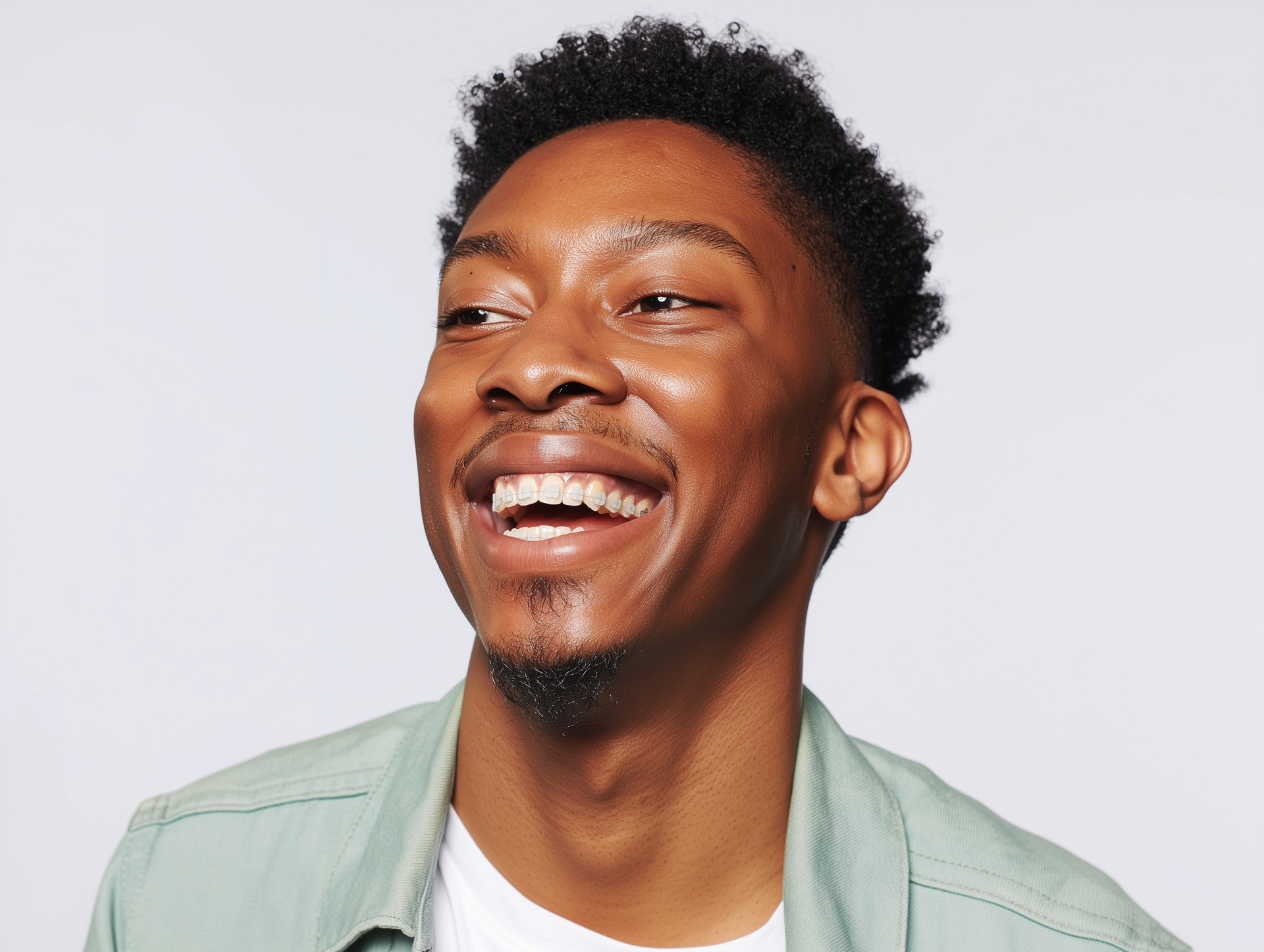 Smiling person in a light green shirt against a white background