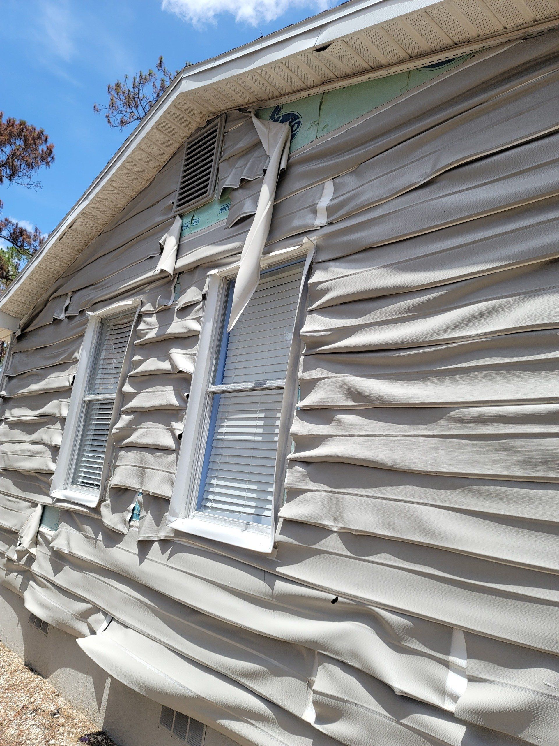 A house with a lot of damage to the siding and windows.