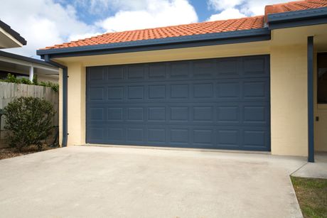 A blue double garage door on a brand new home, after garage door replacement.