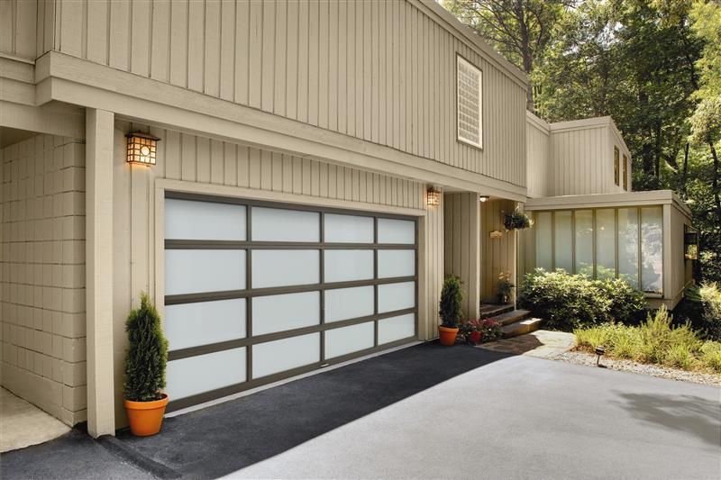 Modern beige house exterior with a double garage, driveway, and landscaped front entrance.