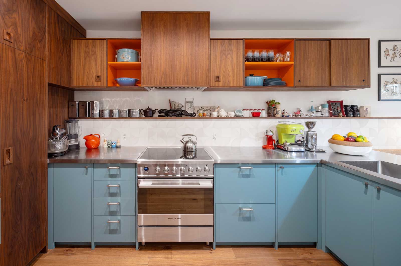 A kitchen with blue cabinets and stainless steel appliances.