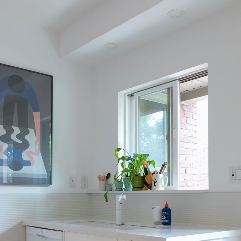 A kitchen with a sink and a picture on the wall