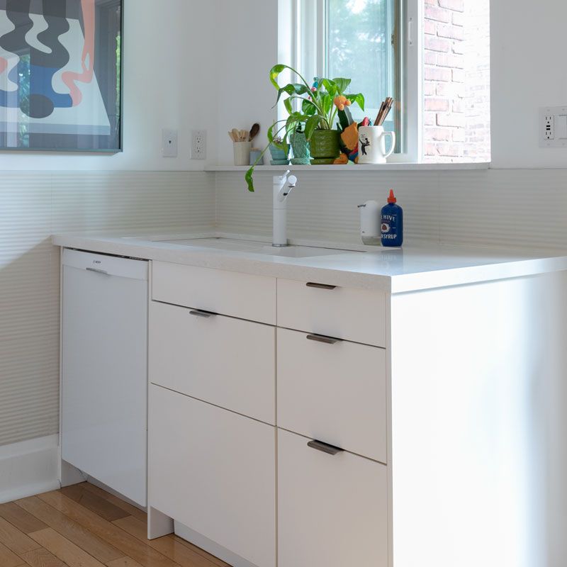A kitchen with white cabinets and a sink