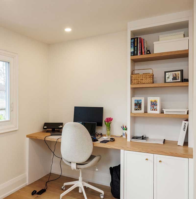 A desk with a computer and a chair in a room