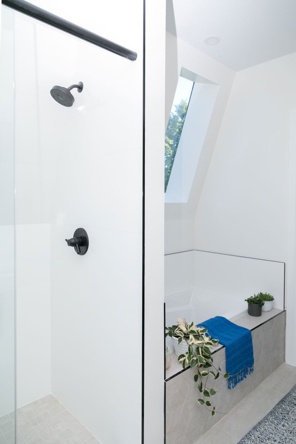 A bathroom remodel with a walk-in shower and a window