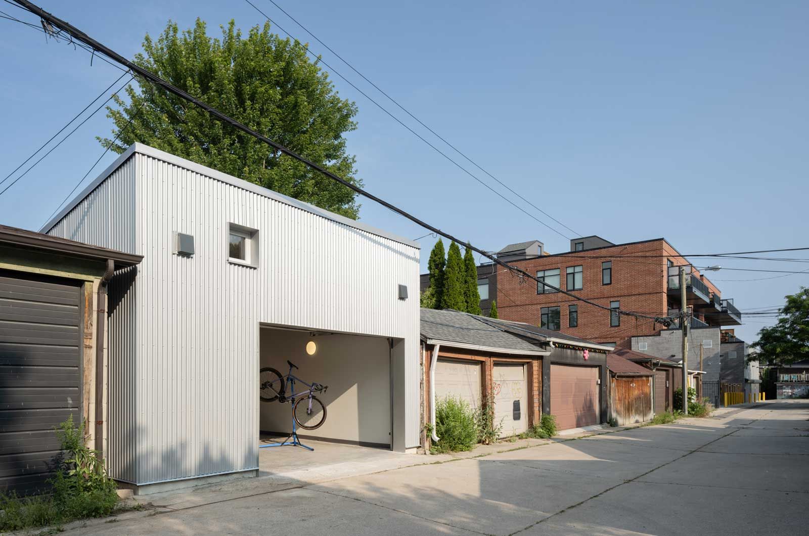 A row of garages are lined up on the side of a street.