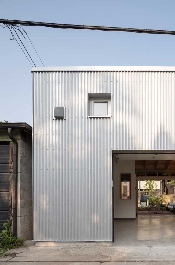 A white building with a garage and a window on the side.