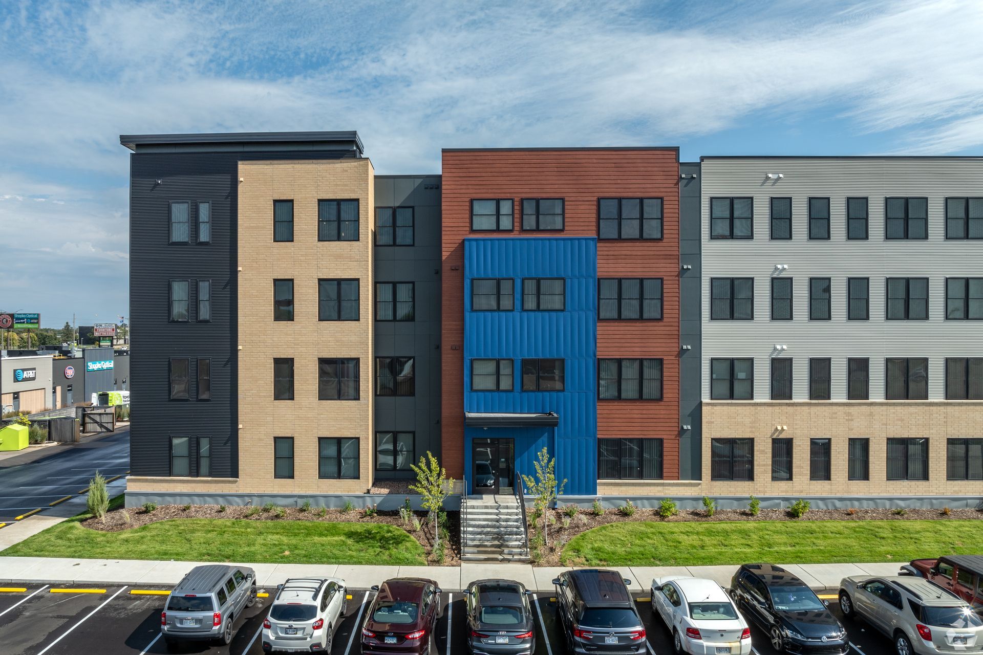 Exterior of a multifamily apartment building with blue, grey and brown tones