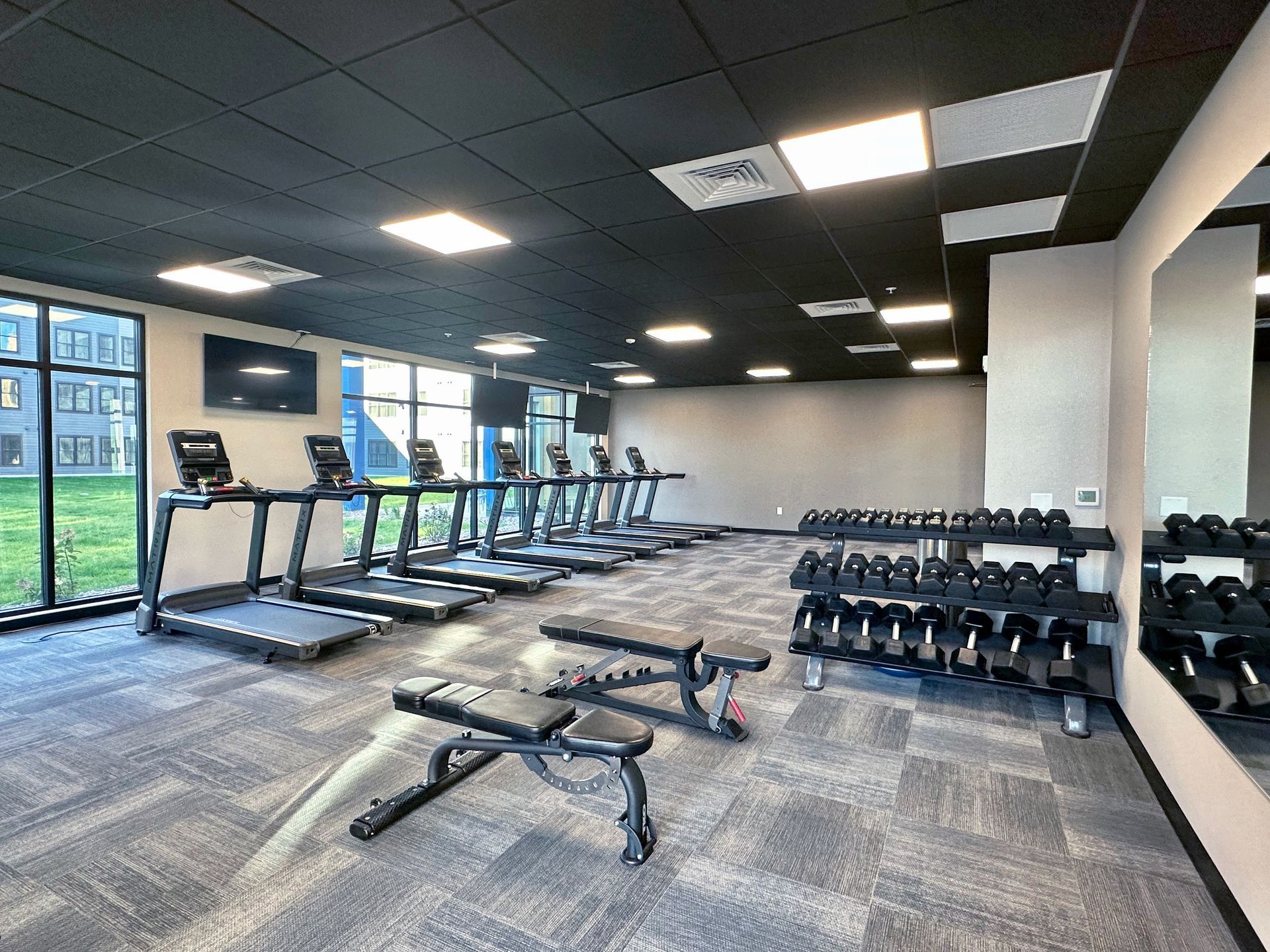Fitness center with treadmills, weights, and weight benches