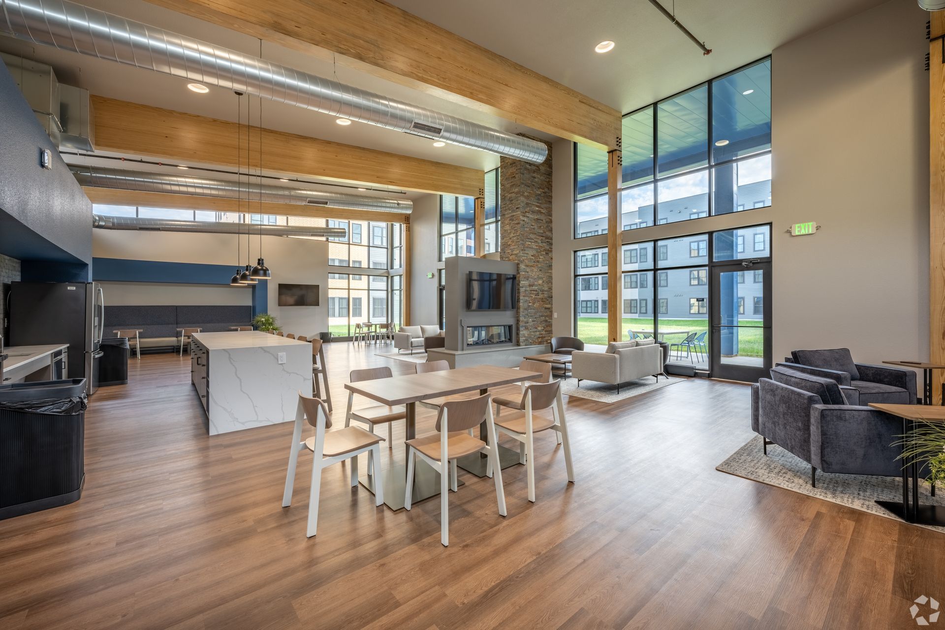 Interior of a community room with a fire place and kitchen area