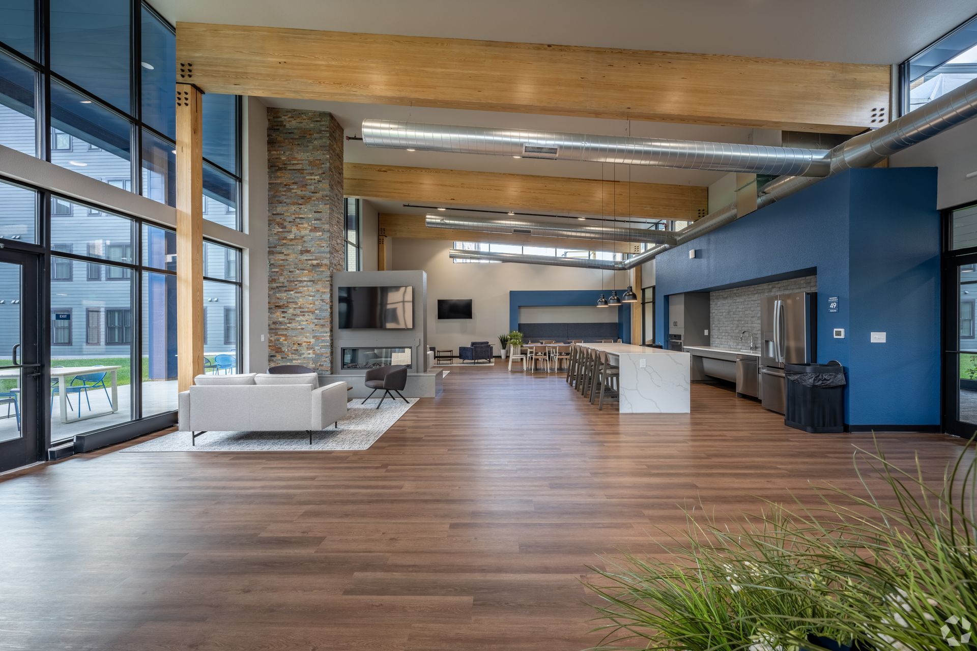 Community room with blue walls, kitchen space and a stone fireplace