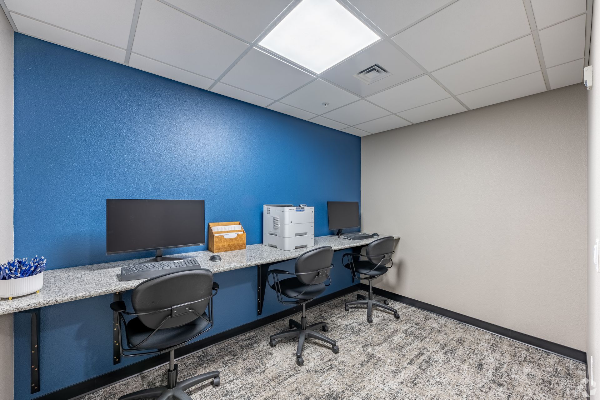 Computer station area with a printer and blue wall
