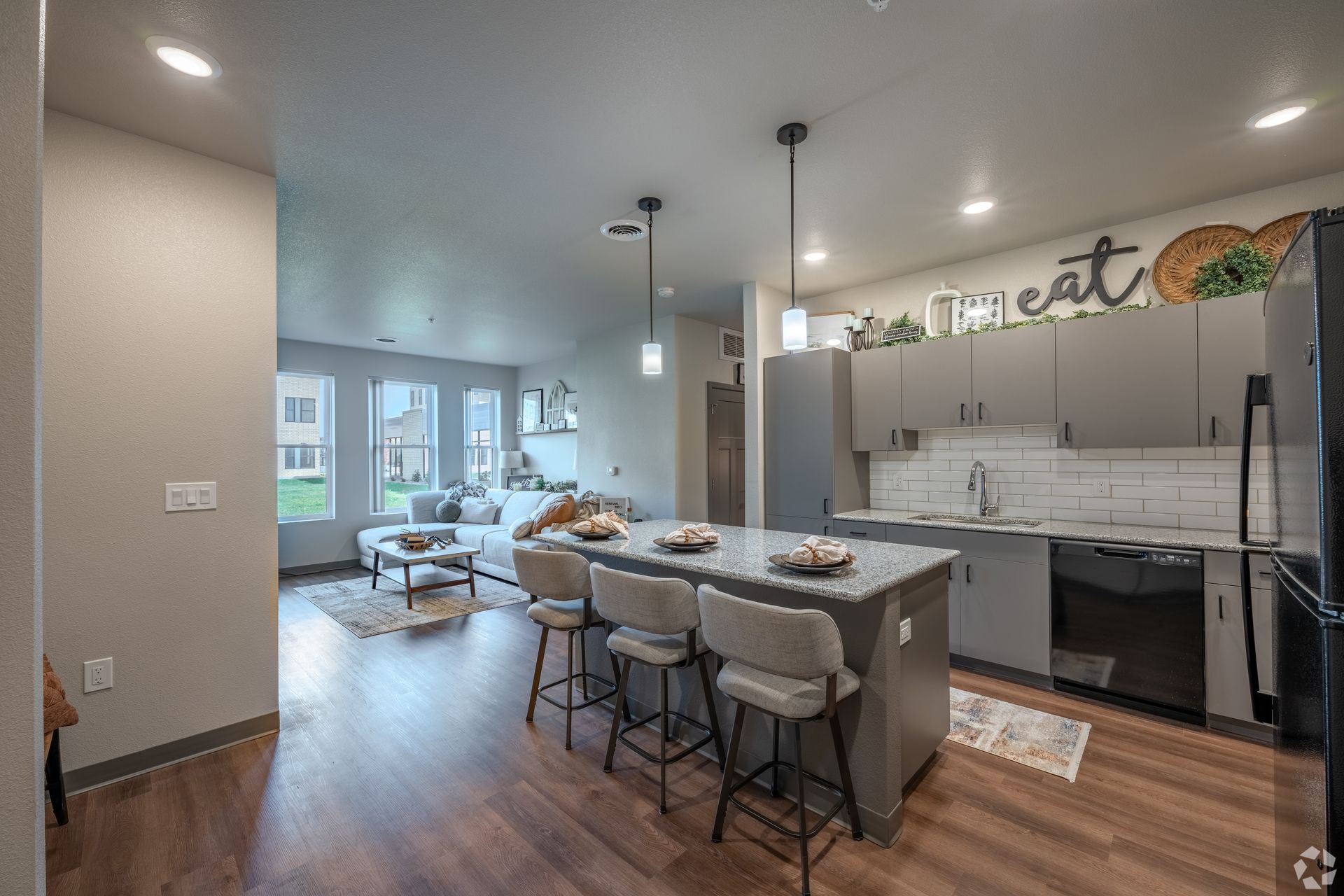 Kitchen with grey cabinets and an island with an open concept to the living room