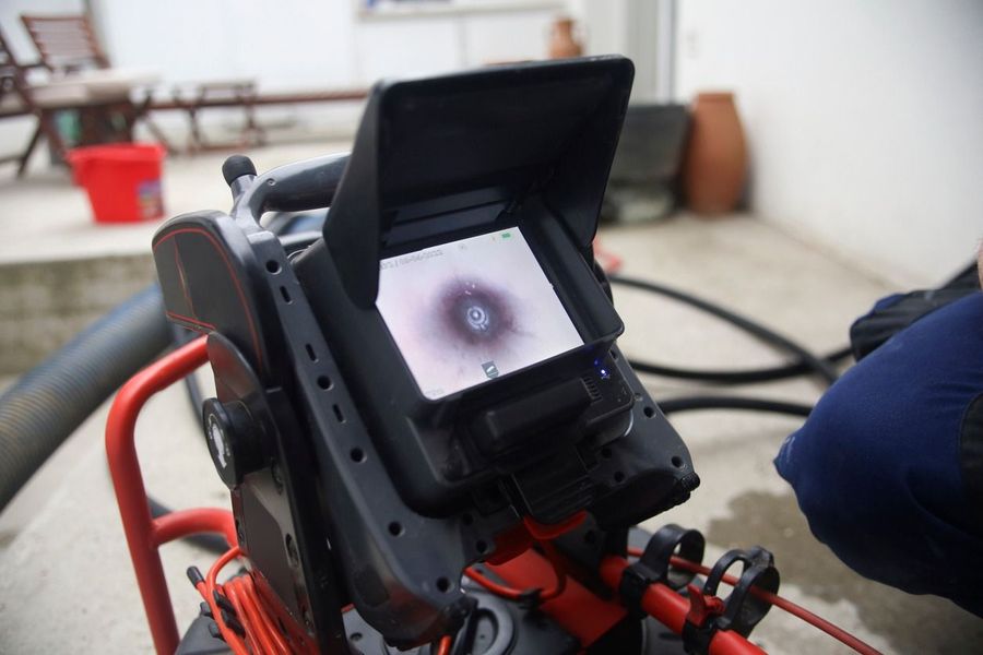 Close-up of a red-and-black monitor showing a circular scan on a device in a workshop