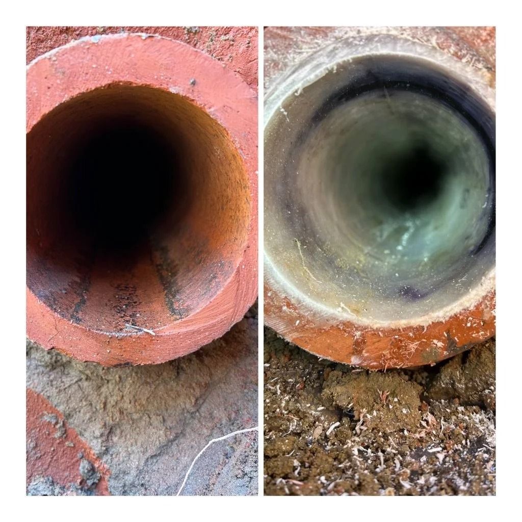 Two rusted pipes side by side, one red-brown and one gray-green, with dark openings.