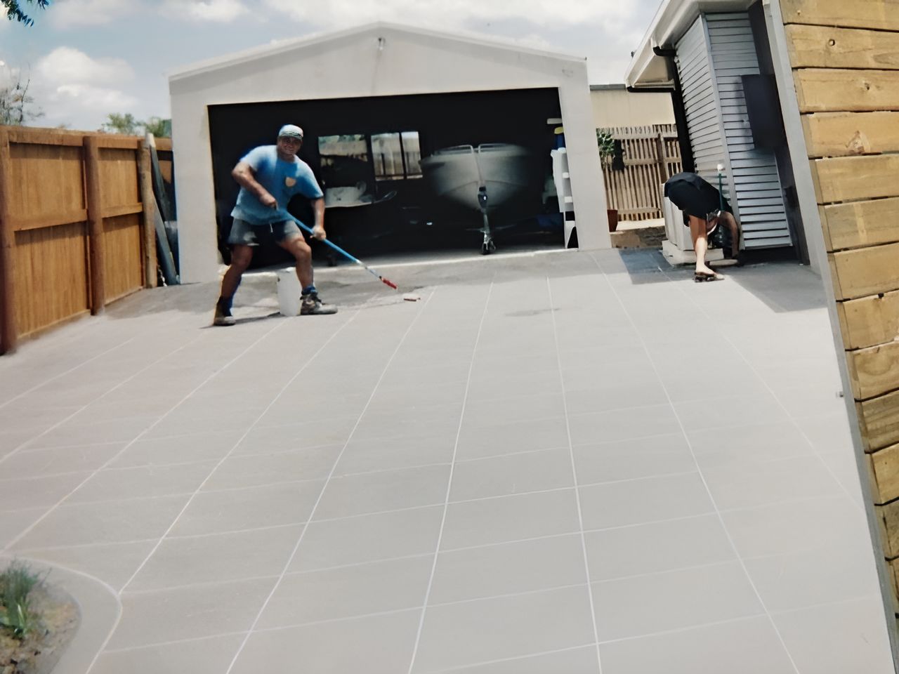A Man Is Standing In Front Of A Garage  — Flash Concreting Pty Ltd In Nindaroo, QLD