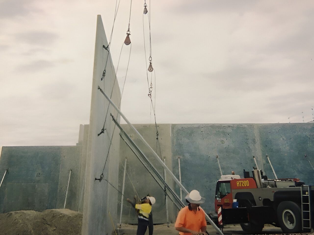A man is standing in front of a crane — Flash Concreting Pty Ltd In Bowen, QLD