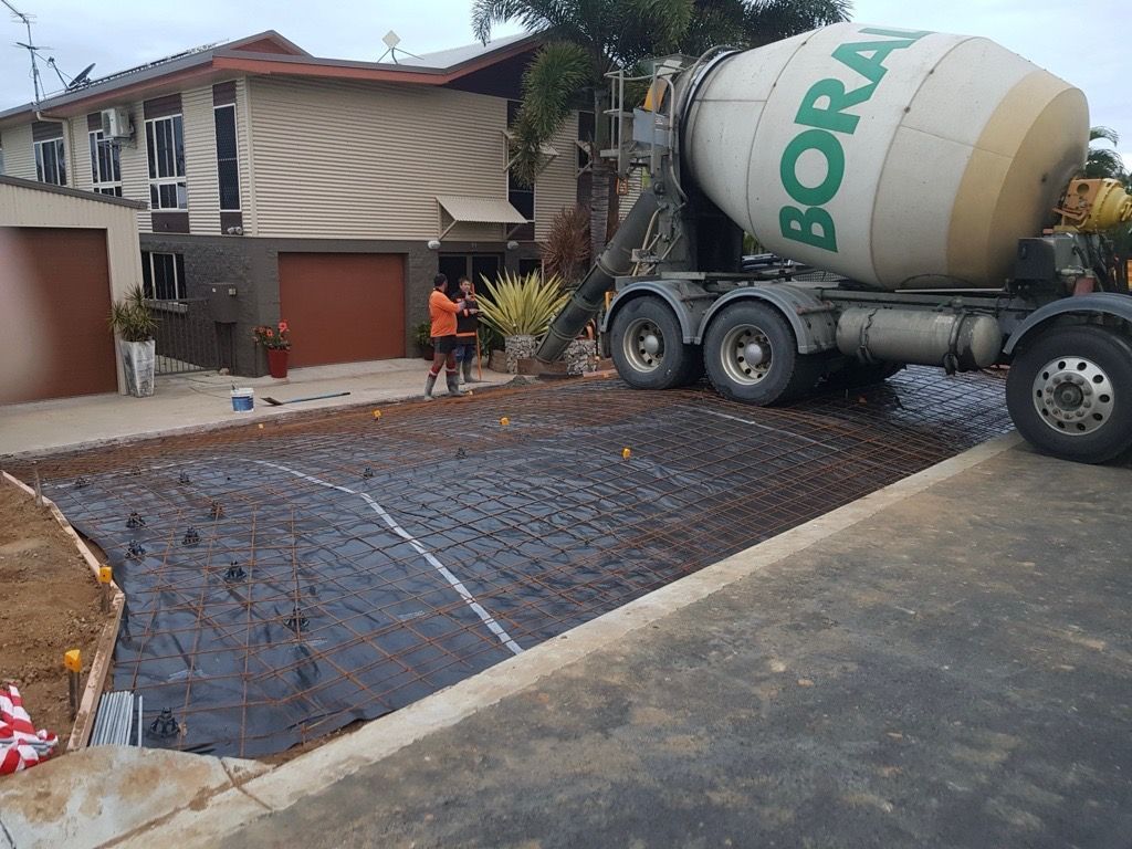 Concrete truck pouring a driveway in front of a house, with workers on site. — Flash Concreting Pty Ltd In Nindaroo, QLD