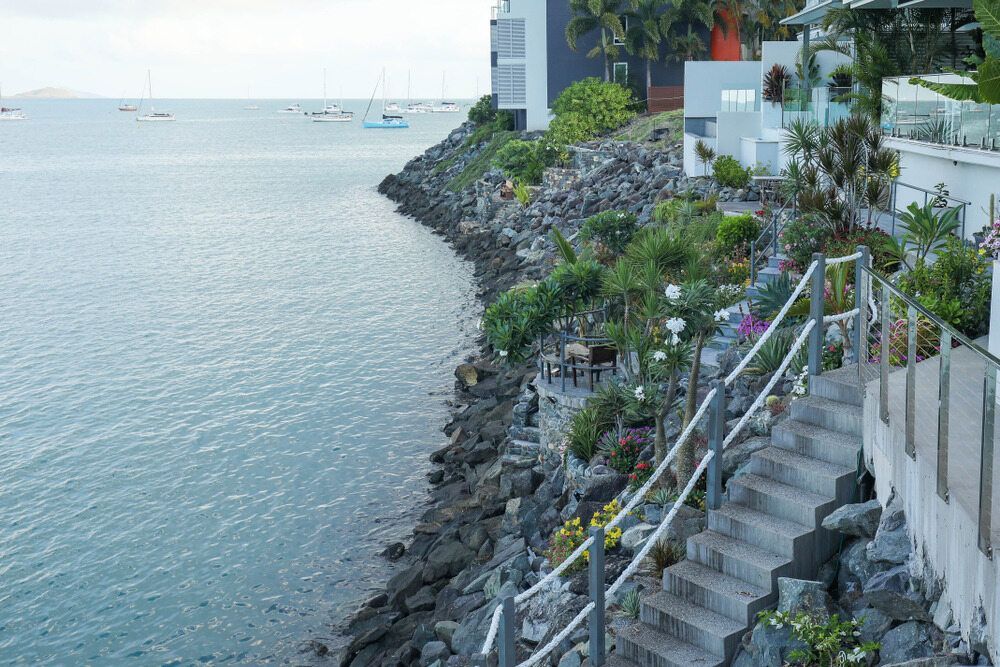 A Staircase Leading Up To A Cliff Overlooking The Ocean — Flash Concreting Pty Ltd In Cannonvale, QLD