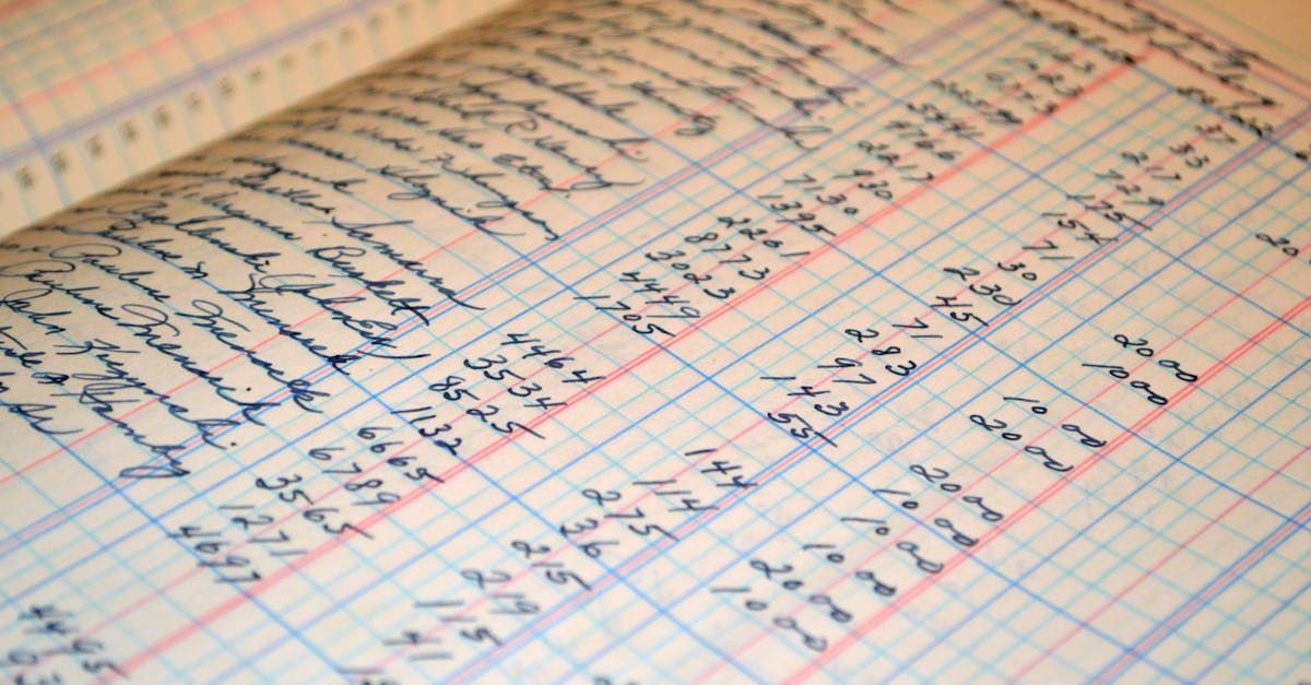 Close-up of an open ledger book, filled with handwritten entries and numerical calculations in blue ink.