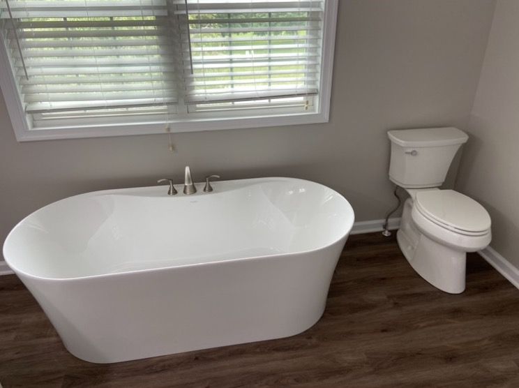 Aqua Plumbing Pros | There is a bathtub and toilet in the bathroom.