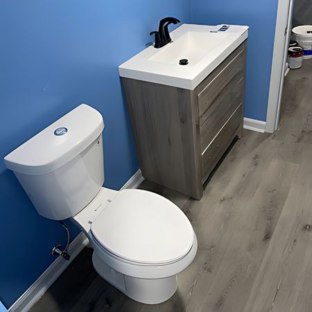 Aqua Plumbing Pros | A bathroom with a toilet , sink , and blue walls.