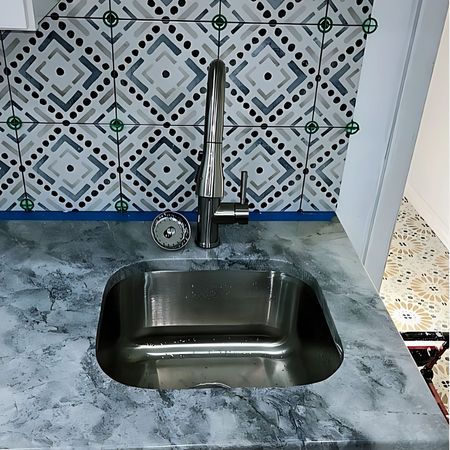 Aqua Plumbing Pros | A stainless steel sink with a faucet in a kitchena