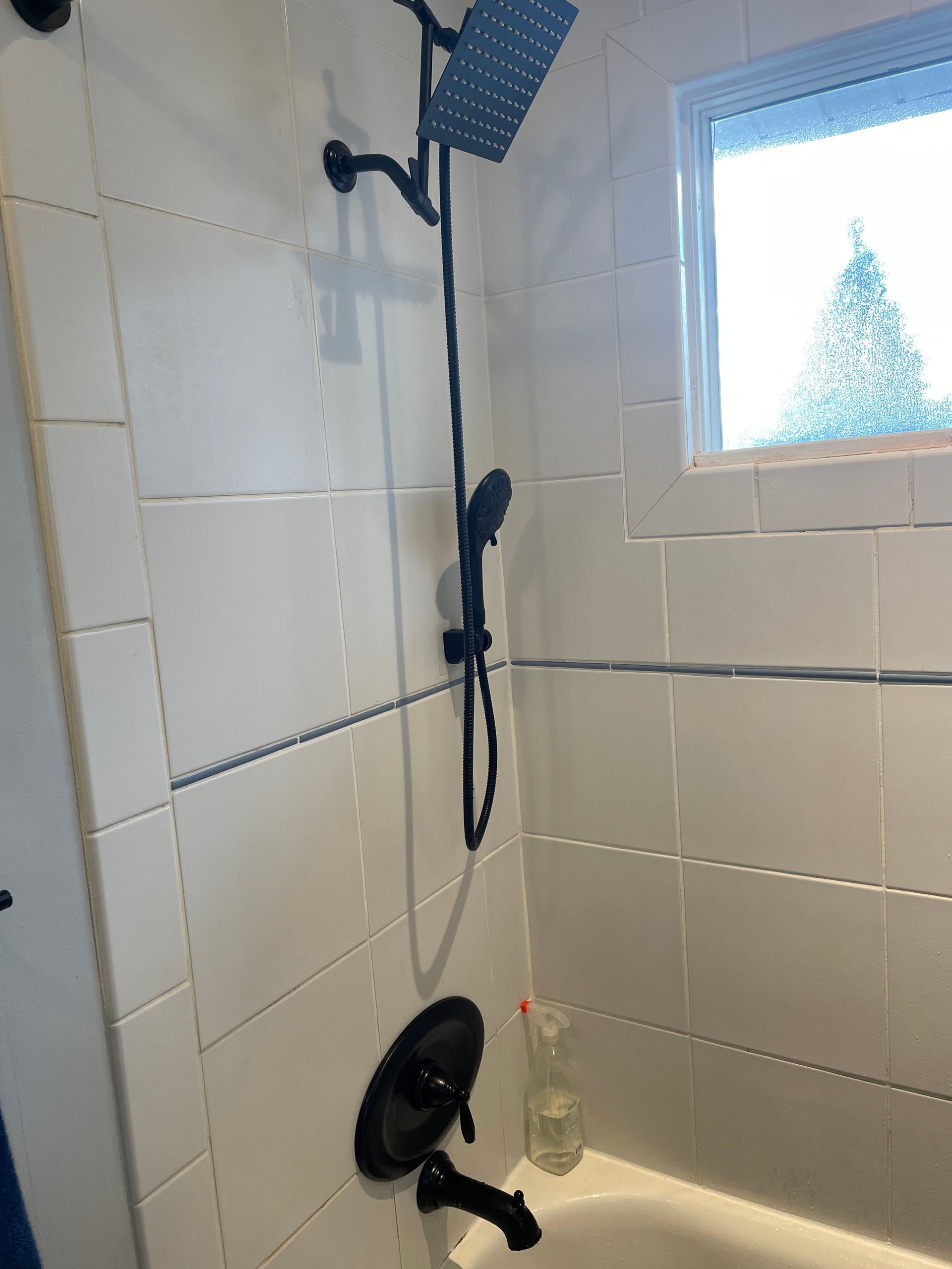 Aqua Plumbing Pros | A bathroom with a shower head and a tub.