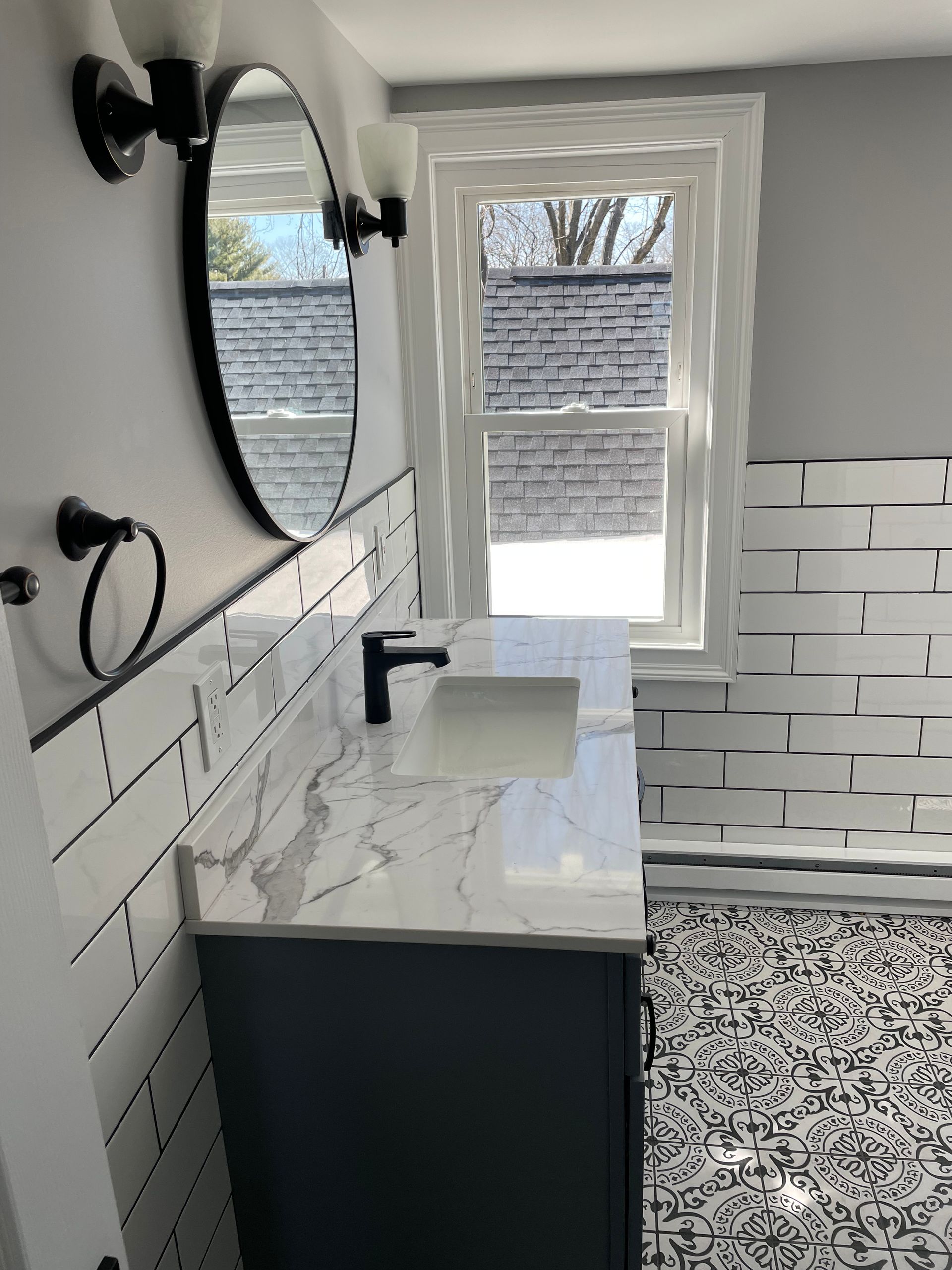 Aqua Plumbing Pros | A bathroom with a sink , mirror , and brick wall.