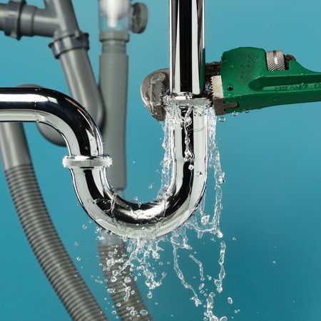 Aqua Plumbing Pros | A green wrench is being used to fix a sink pipe