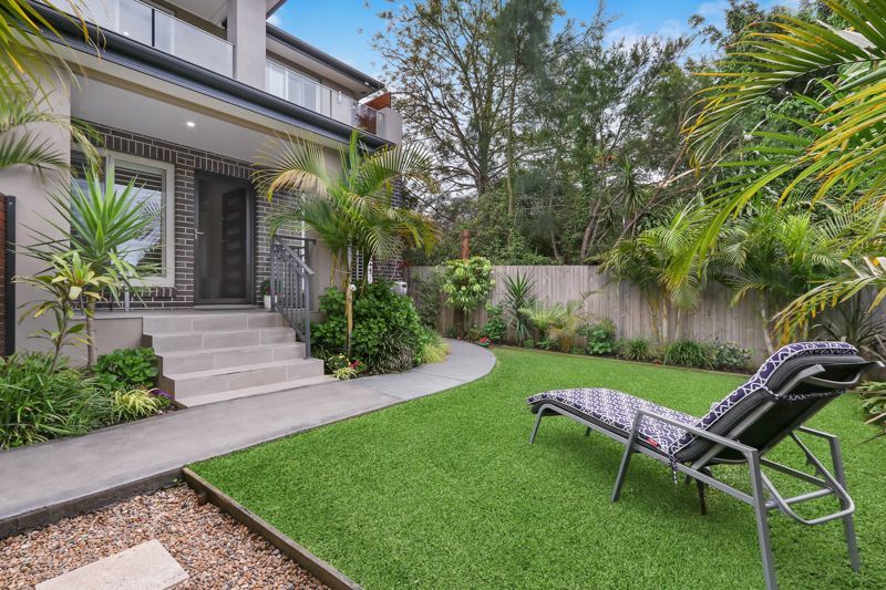 There is a lawn chair in the backyard of a house.