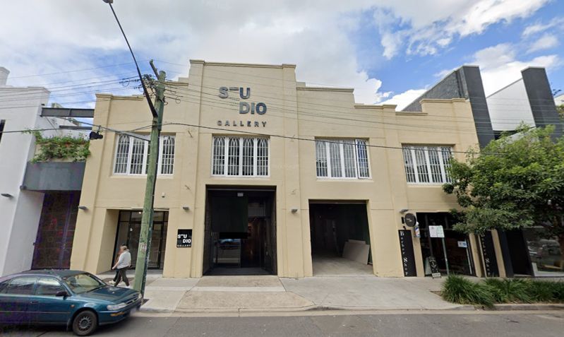 A car is parked in front of a building that says studio dio