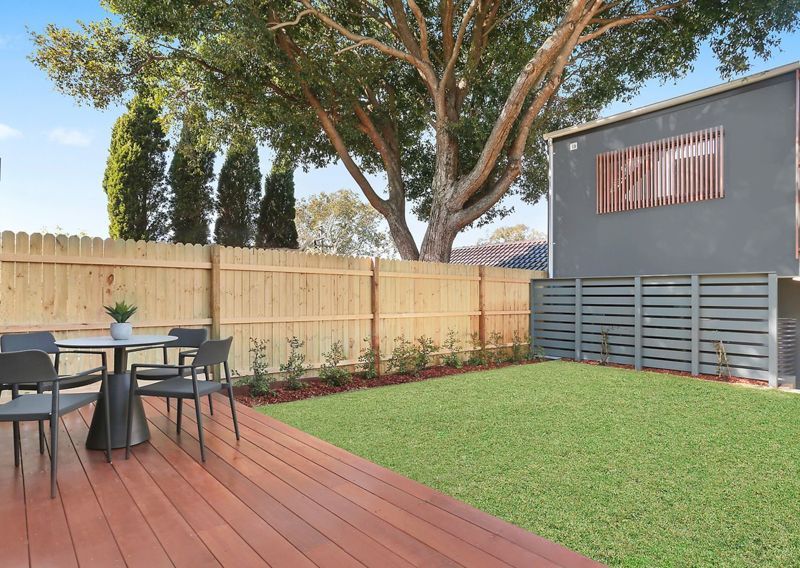 There is a table and chairs on the deck in the backyard.