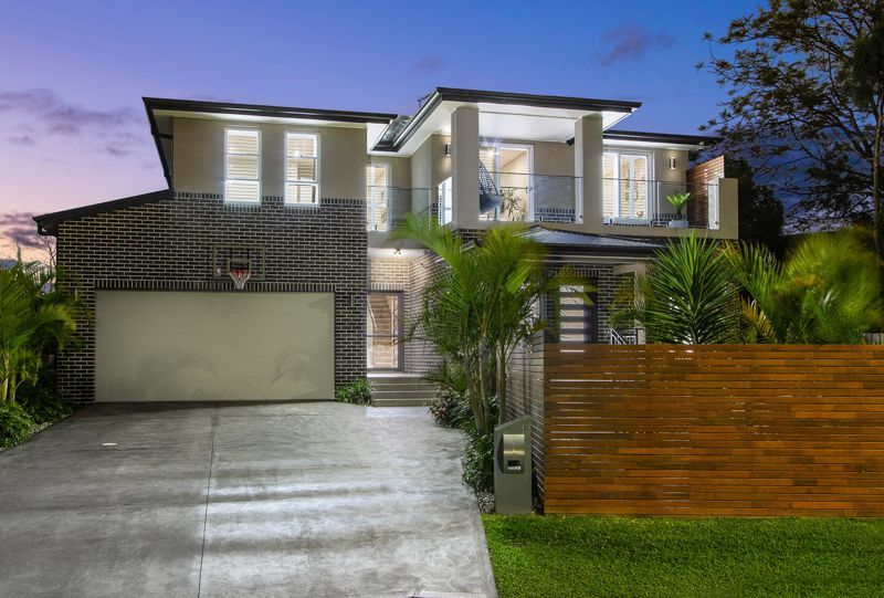 A large house with a garage and a wooden fence in front of it.