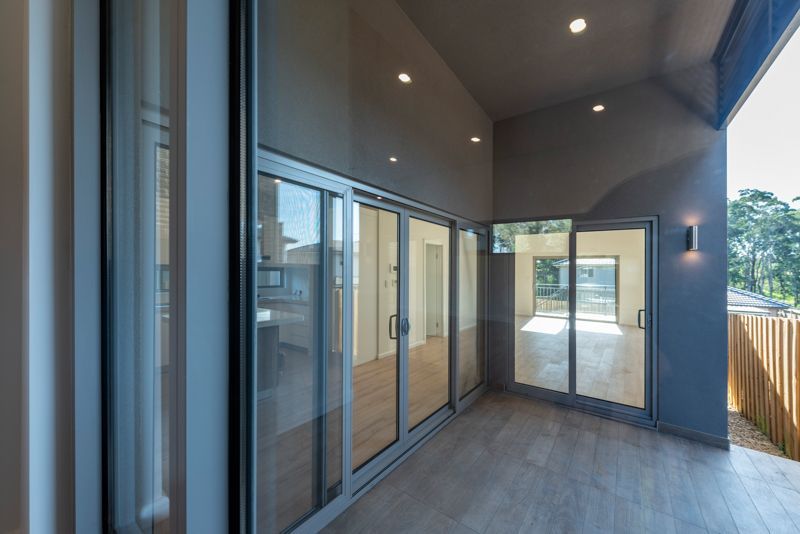 A balcony with sliding glass doors and a wooden floor in a house.