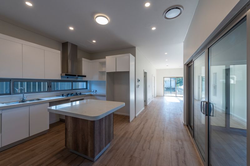 An empty kitchen with a large island in the middle of the room.
