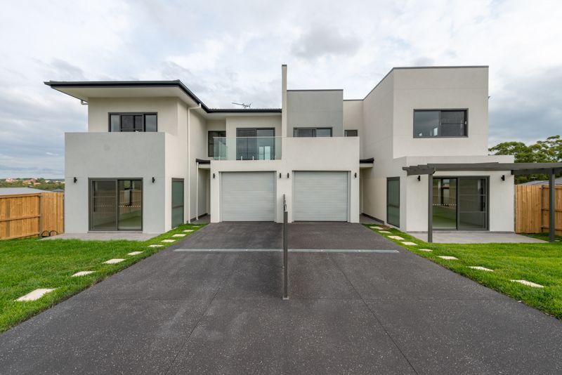 A large white house with two garages and a driveway