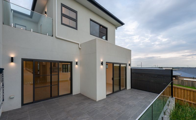 A white house with a balcony and sliding glass doors