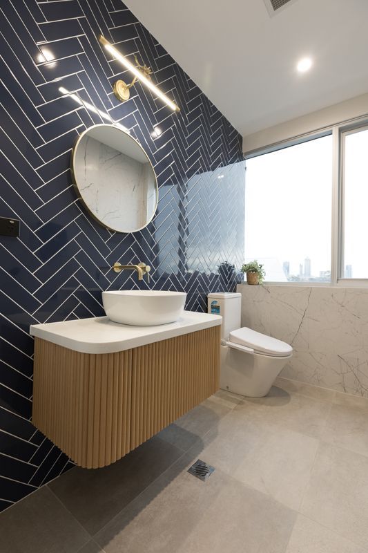 A bathroom with a sink , toilet and mirror.