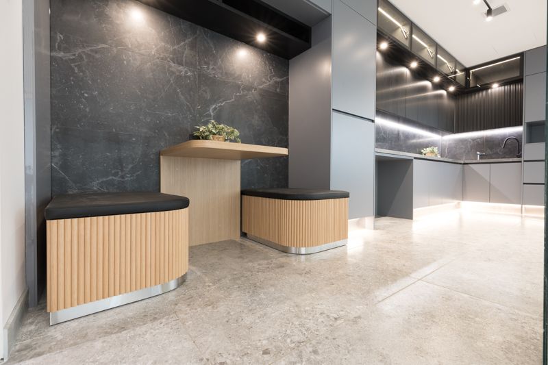 A kitchen with a table and benches in a corner.