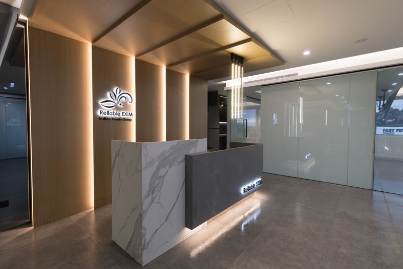 A reception area with a marble counter and a glass wall