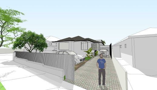 A man is standing on a sidewalk in front of a house.