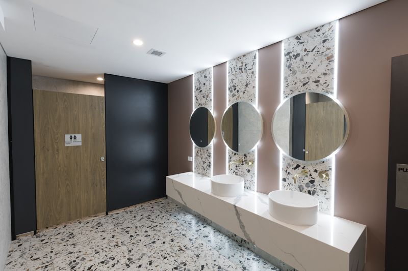 A bathroom with two sinks and three mirrors.