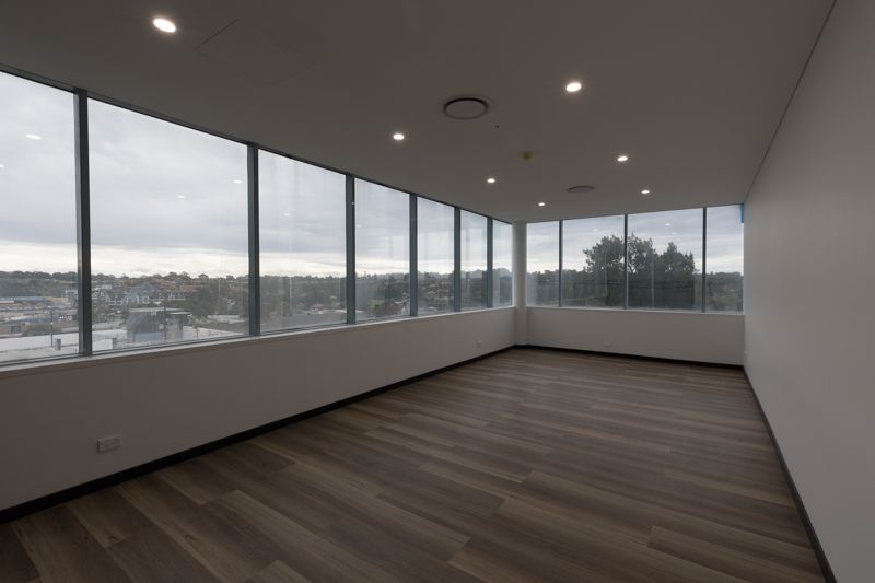 An empty room with a lot of windows and wooden floors