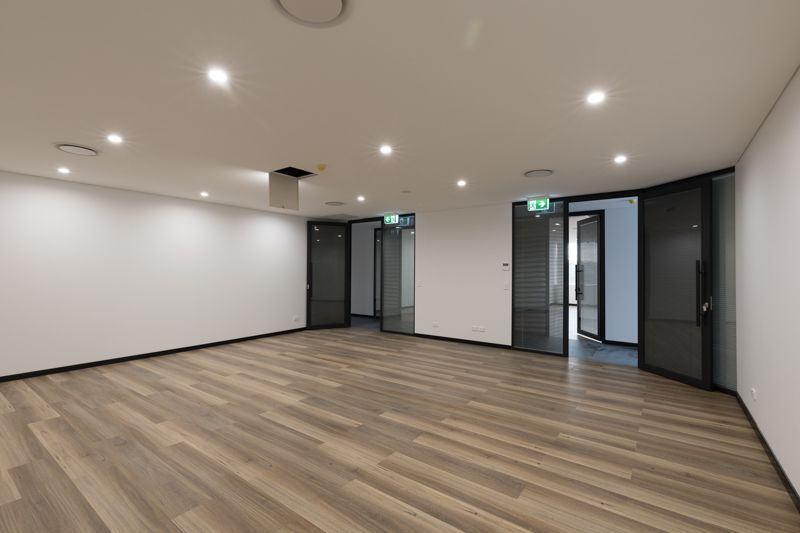 An empty room with wooden floors and white walls