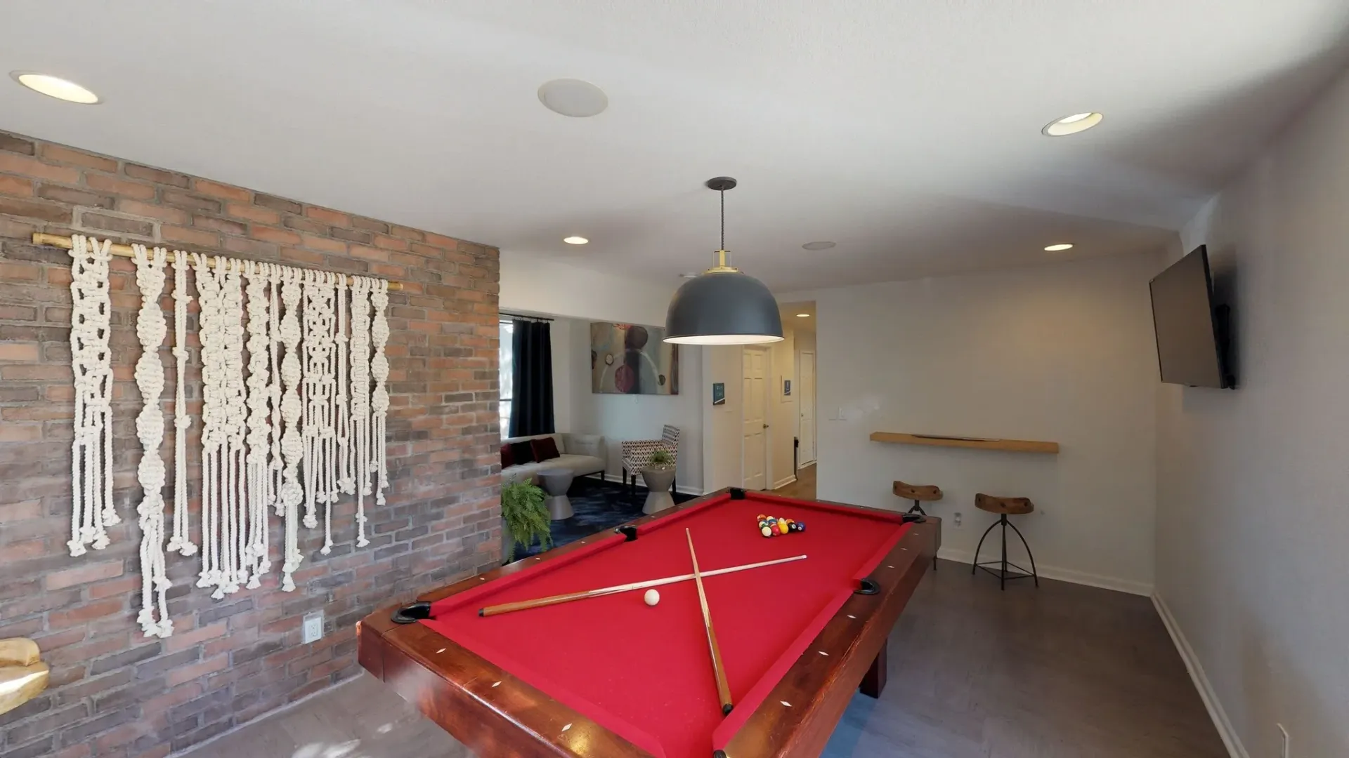 Community game room with a pool table, seating area, and TV.